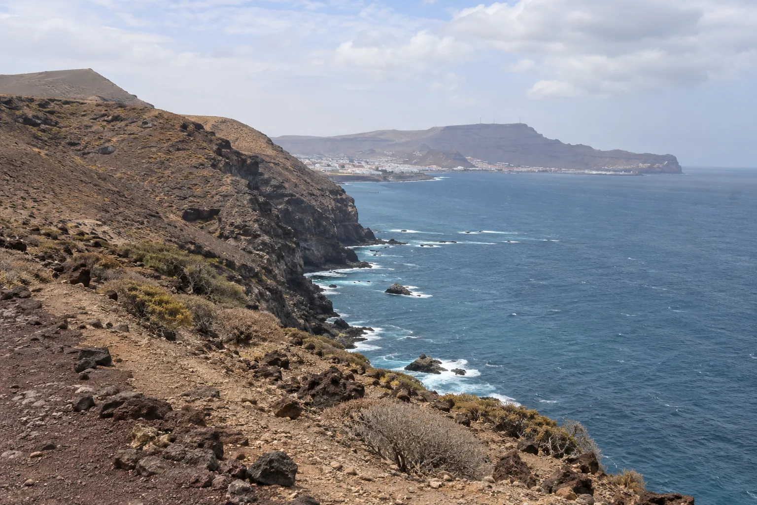Droge vulkanische kusthellingen en de Atlantische Oceaan bij Gran Canaria