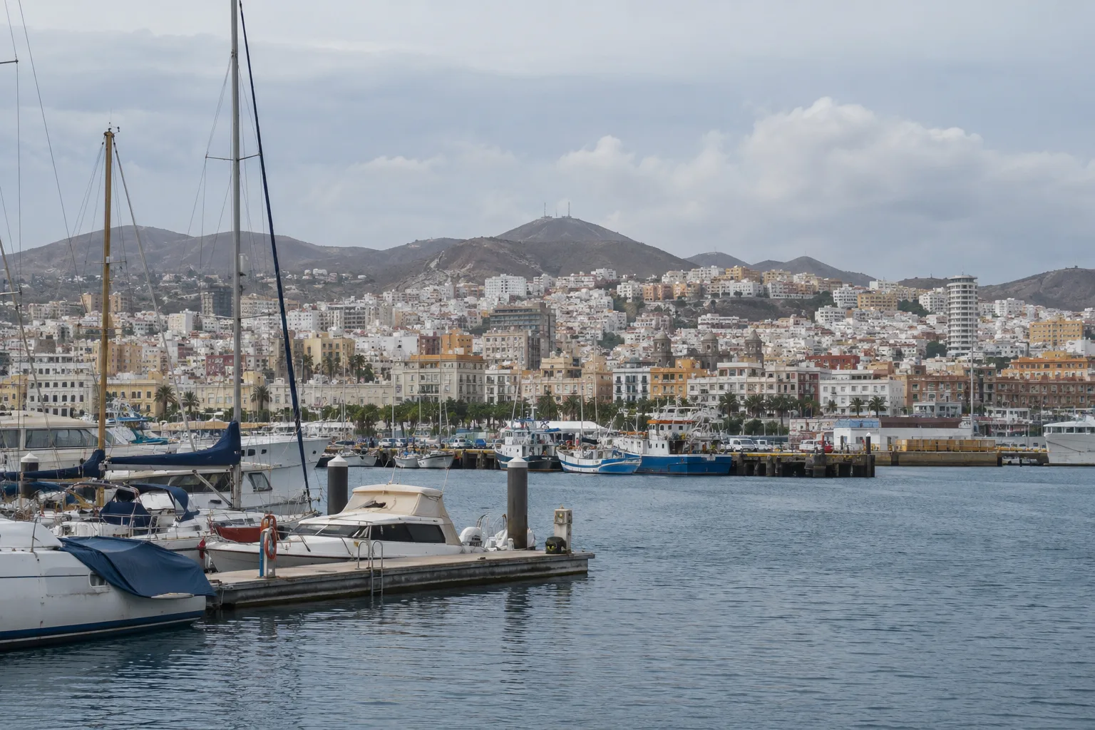Havenwater, boten en bebouwing van Las Palmas onder een bleke lucht